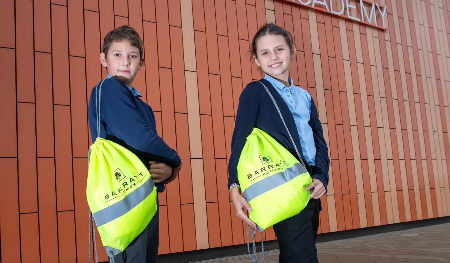 Two pupils at Wintringham Primary Academy with the kit bags donated by Barratt Homes
