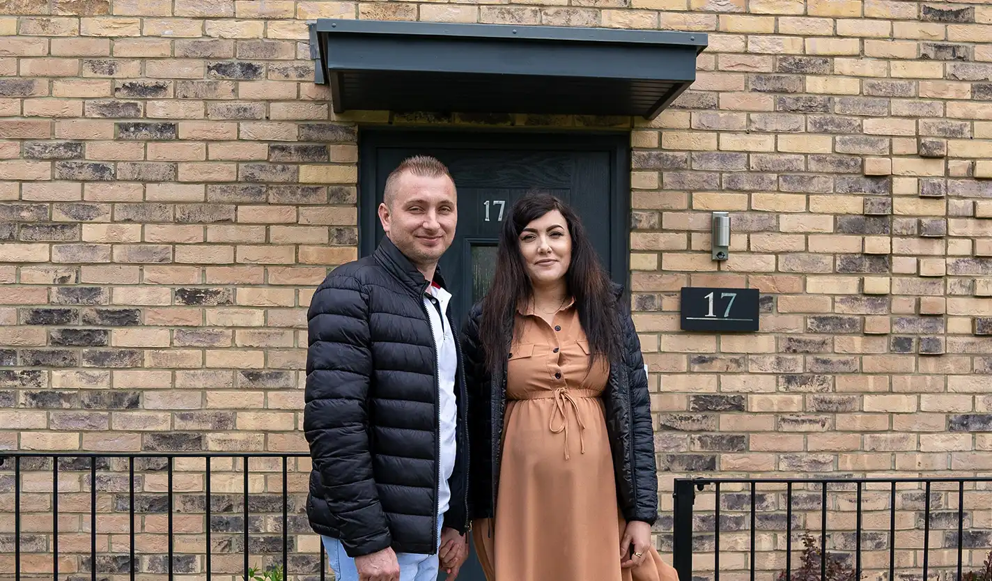 Ciprian and Dana standing in front of their home's front door