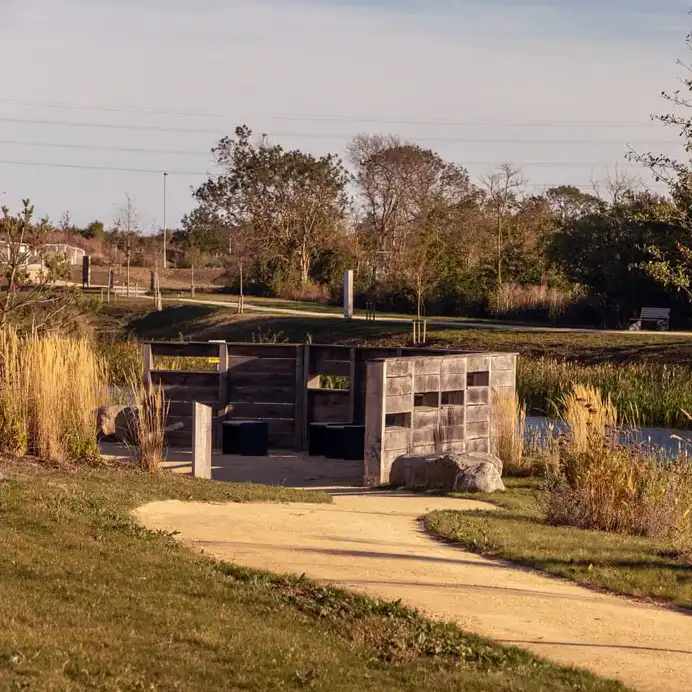 Bird hide beside a pond with reeds and grassland within a housing development nature area