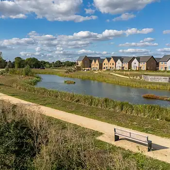Wintringham Waters lake and leisure trail with a bench overlooking new homes and landscaped waterside gardens